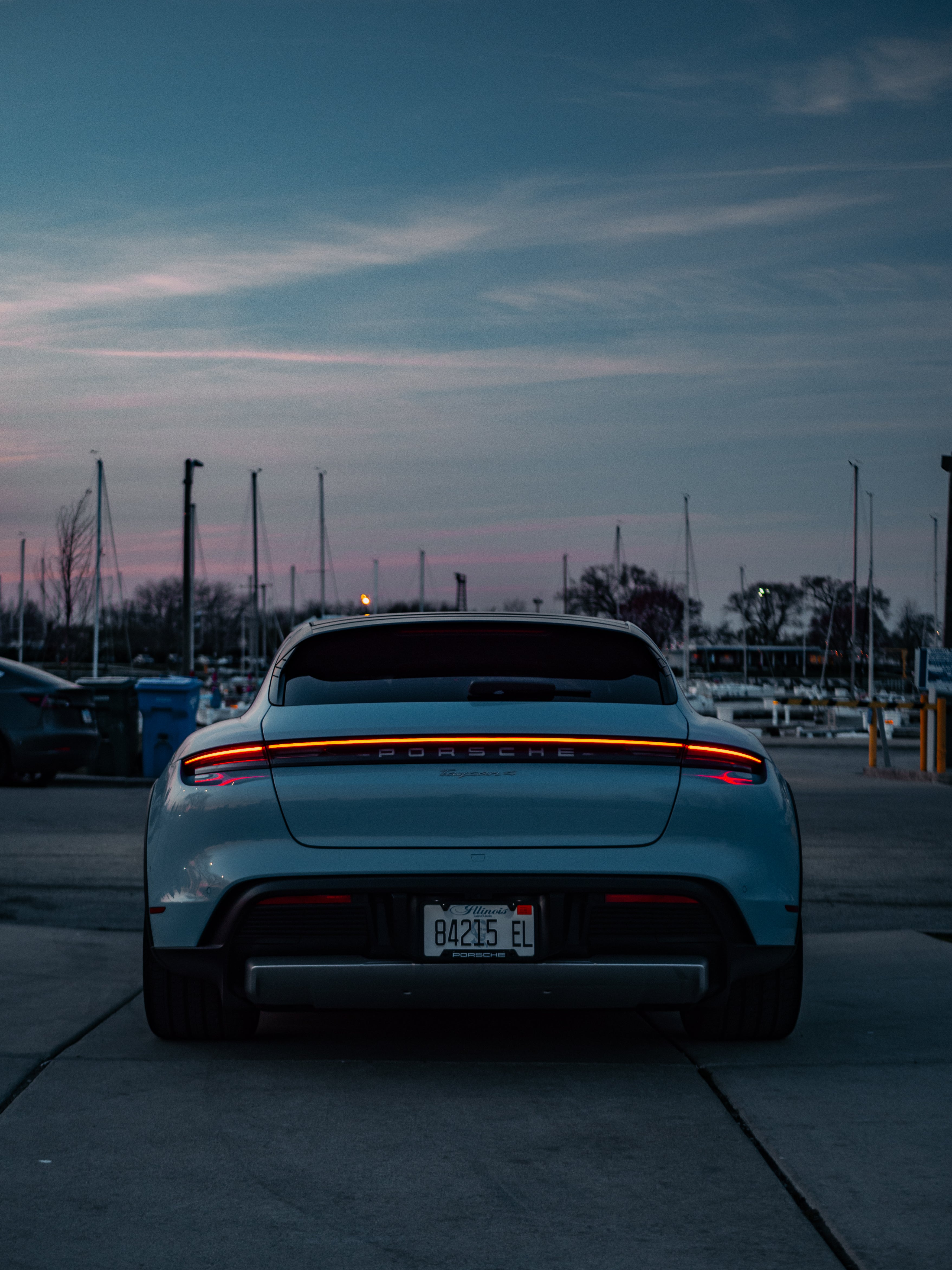 Porsche Taycan 4 rear view featuring sleek taillights, sporty design, and electric performance details.