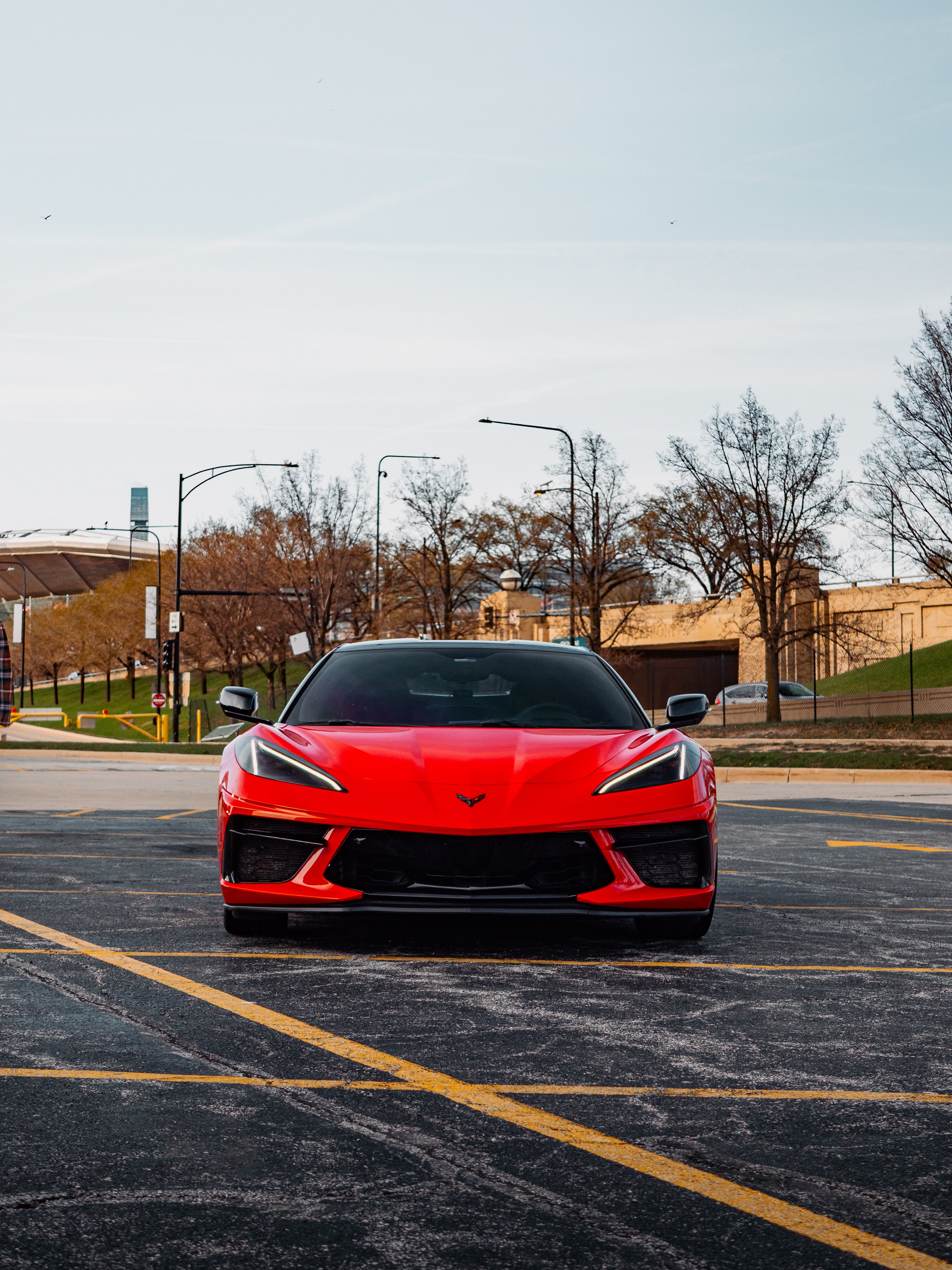 C8 Corvette front side view showcasing bold red exterior, sleek aerodynamic design, and aggressive sports car styling.