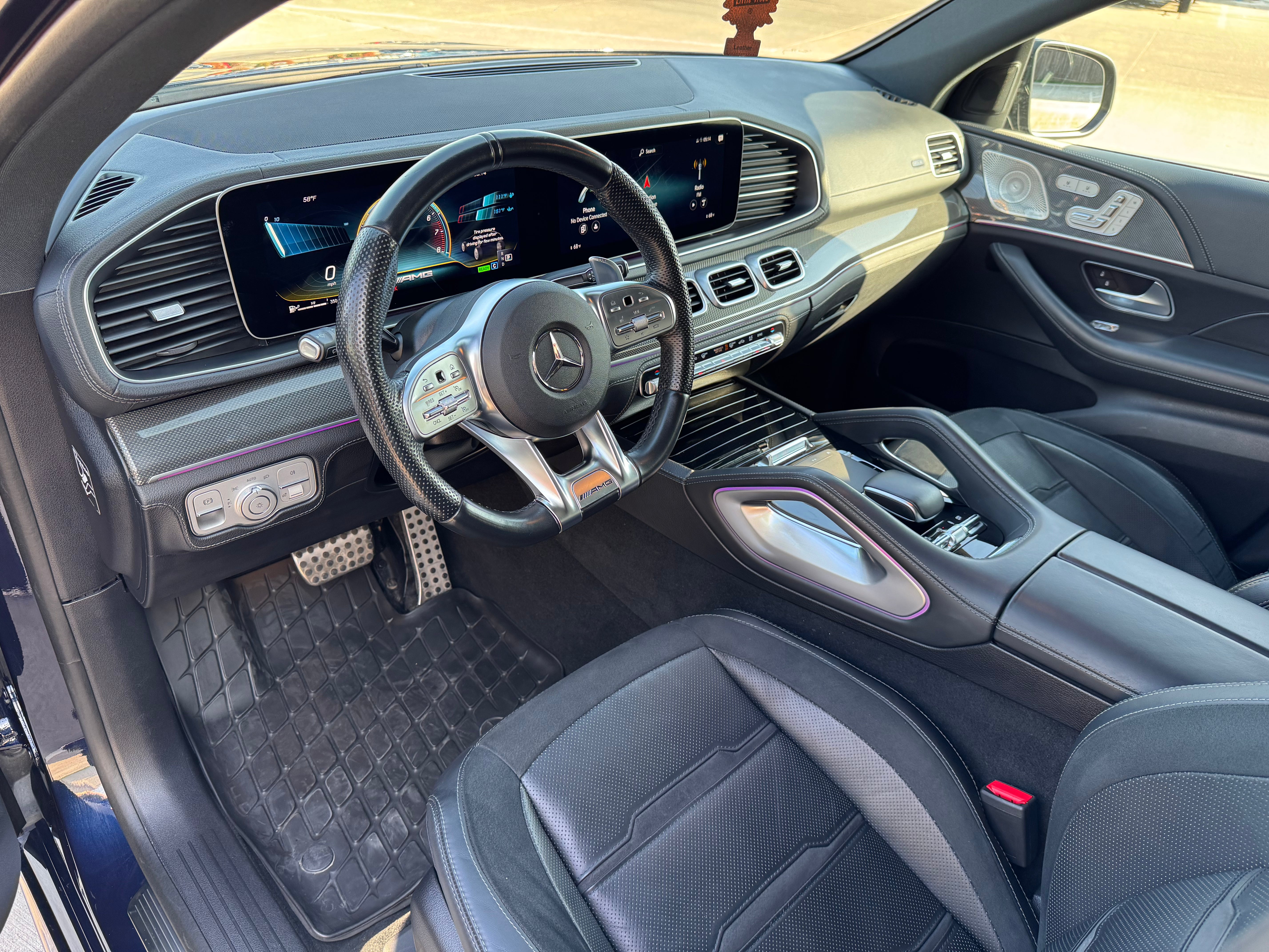 Mercedes-AMG GLE 53 close-up view of the steering wheel and touchscreen, featuring premium leather detailing, AMG logo, and advanced infotainment system.